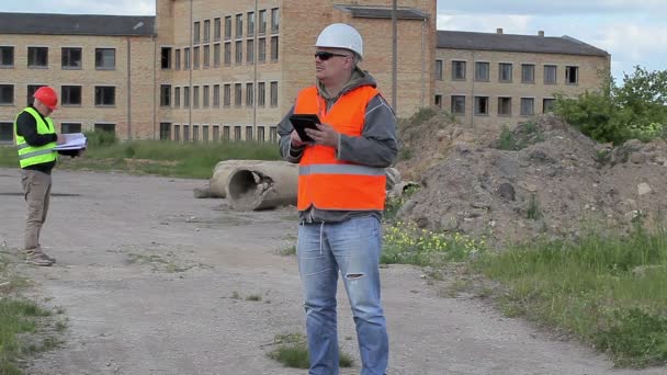 Empleados de construcción cerca de edificio inacabado — Vídeos de Stock