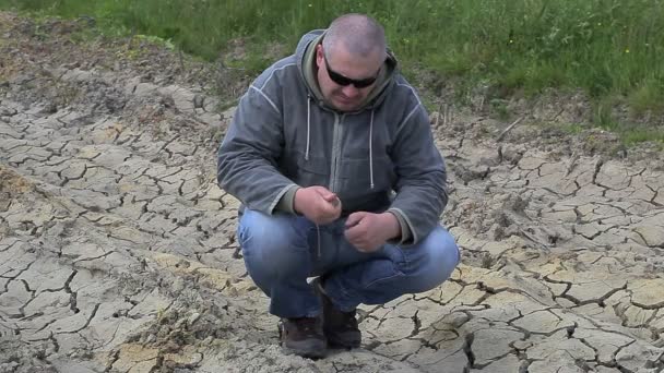 Homem em chão seco rachado — Vídeo de Stock