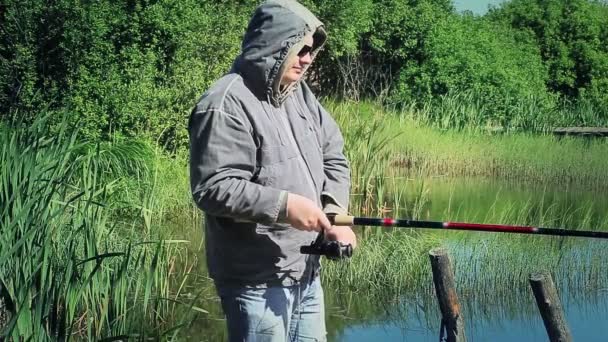 Fisherman with fishing rod near the lake in morning — Stock Video