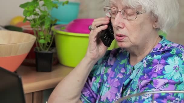 Пожилая женщина разговаривает по телефону — стоковое видео
