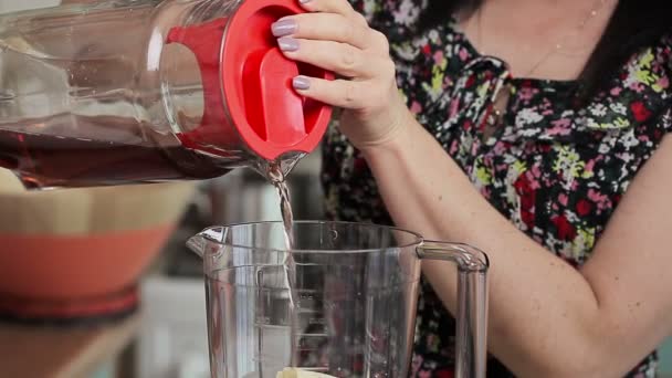 Vrouw SAP gieten in de blender — Stockvideo