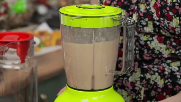 Women turn on blender with milkshake — Stock Video