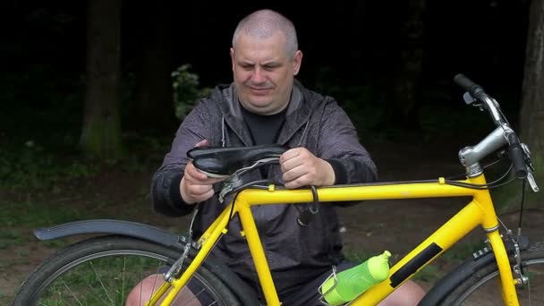 Man fixing bicycle seat — Stock Video