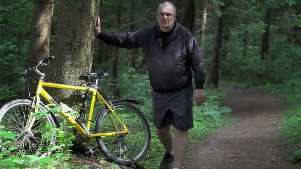 Homem se aquece perto de bicicleta no parque — Vídeo de Stock