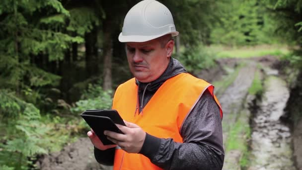 Lesní úředník s počítačem tablet Pc na rozježděná lesní cestě — Stock video