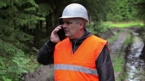 Лісовий офіцер розмовляє по мобільному телефону на лісовій дорозі — стокове відео