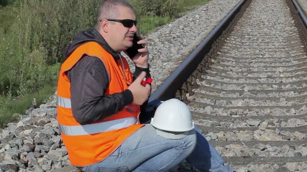 Železniční inženýr s smartphone a láhev vody — Stock video