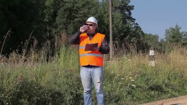 Järnväg ingenjör med flaska vatten nära railway — Stockvideo