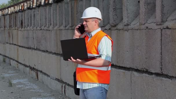 Engineer talking on phone near wall — Stock Video