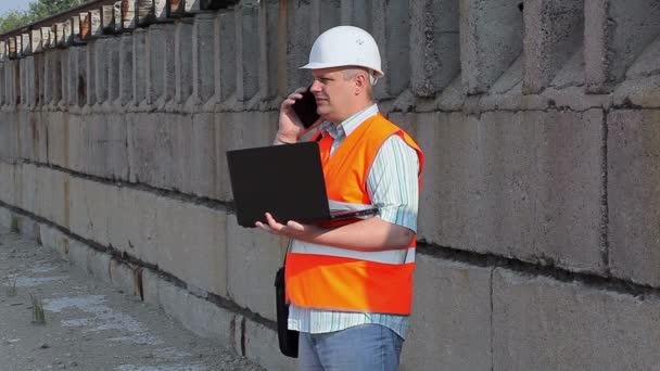 Ingenieur telefoniert nahe der Mauer — Stockvideo