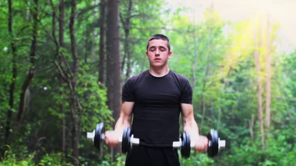 Teenager exercising with dumbbells for shoulders — Stock Video