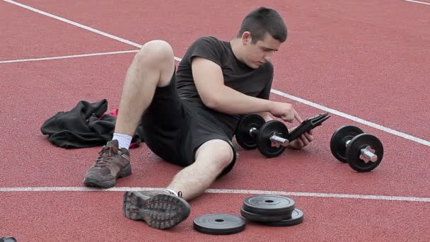 Adolescente usando tableta PC en el campo de deportes — Vídeos de Stock