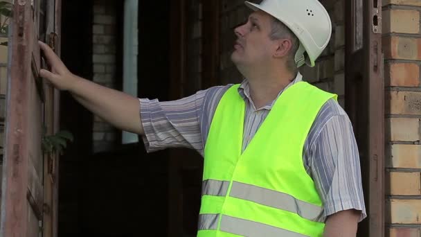 Inspektor budowlany blisko drzwi łamane — Wideo stockowe
