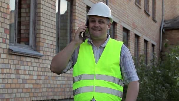 Building inspector talking on smartphone — Stock Video
