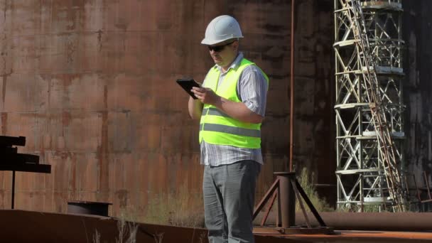 Ingenieur mit Tablet-PC in der Nähe der Tanks — Stockvideo