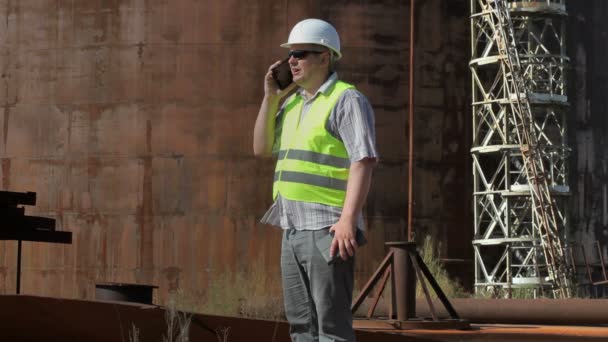 Ingeniero usando smartphone cerca de los tanques — Vídeos de Stock