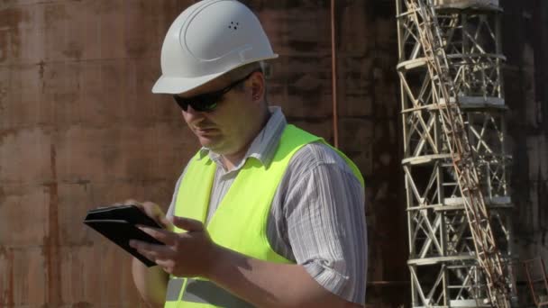 Ingenieur nutzt Tablet-PC im Außenbereich in Tanknähe — Stockvideo