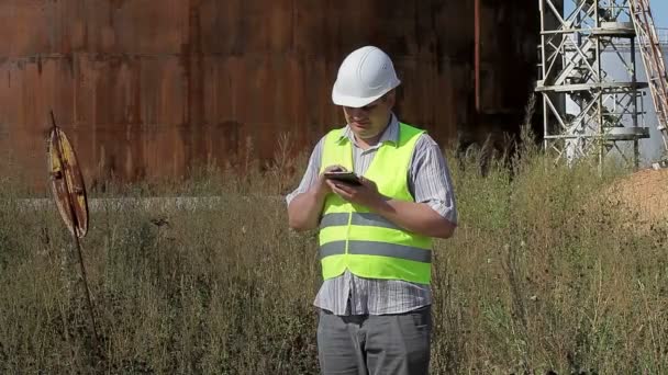 Przemyślane inżynier za pomocą tabletu Pc w pobliżu zbiorników — Wideo stockowe