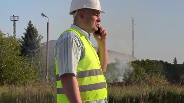 Inspecteur met smartphone in de buurt van Burning grass — Stockvideo