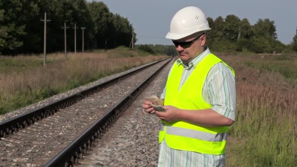 Engenheiro ferroviário para contar dinheiro na ferrovia — Vídeo de Stock