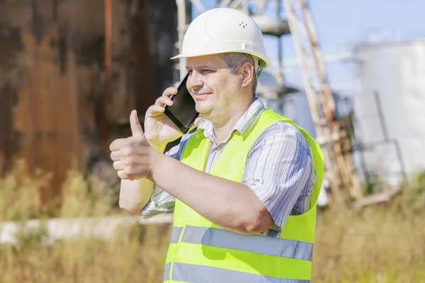 Engineer showing thumb up near to the tanks — Stock Photo, Image