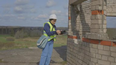 Kameralı şirin bir kadın bina durumunu gösteriyor.