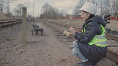Kadın, tabletle çalışan bir demiryolu çalışanı.