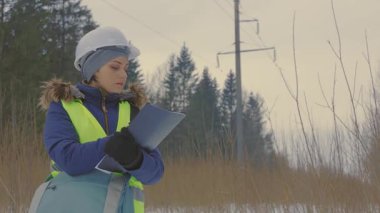Kadın yüksek voltaj hattını denetliyor.