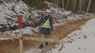 Kadın, yolun sınırlarını kontrol eder.