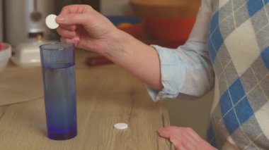 Kadının elini kapat ve bir bardak suya hap at.