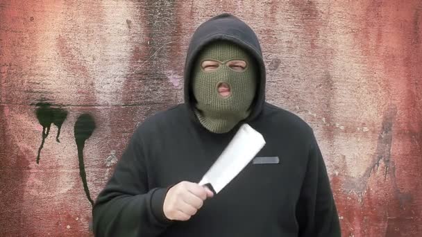 Человек с кухонным ножом у стены — стоковое видео