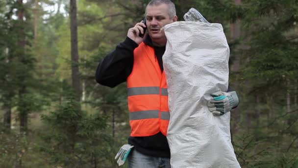 Man met mobiele telefoon en tas van plastic flessen — Stockvideo