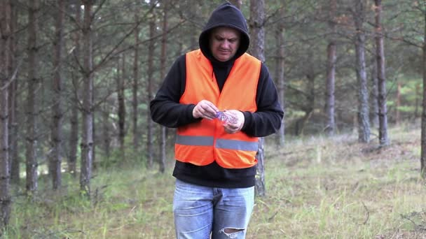 Mężczyzna kompresuje plastikowe butelki i spadł na ziemię — Wideo stockowe