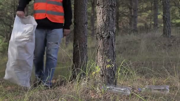 Homme avec sac ramassant des bouteilles en plastique — Video