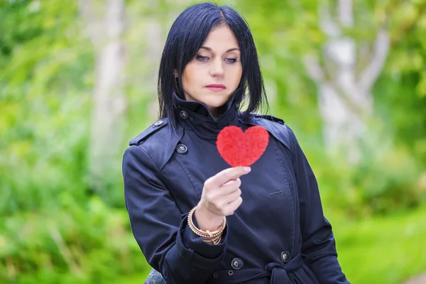 Woman in focus with heart in hand — Stock Photo, Image