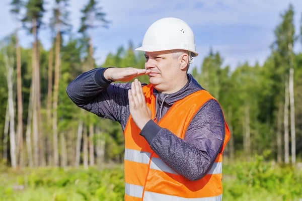 Trabalhador mostrando tempo fora gesto na floresta — Fotografia de Stock