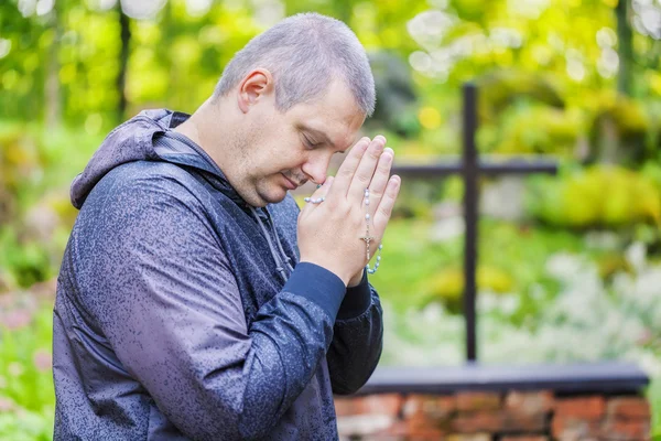 Homme au chapelet priant à l'extérieur — Photo