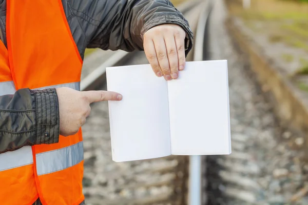 Eisenbahningenieur mit aufgeschlagenem leeren Buch über die Bahn — Stockfoto