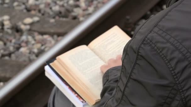 Ember olvasókönyv közelében railway — Stock videók