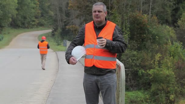 Werknemers met helm, tablet Pc en koffie op de brug — Stockvideo