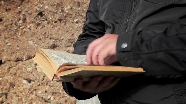 Άνθρωπος με βιβλίο στην υπαίθρια κοντά στο παλιό τείχος — Αρχείο Βίντεο