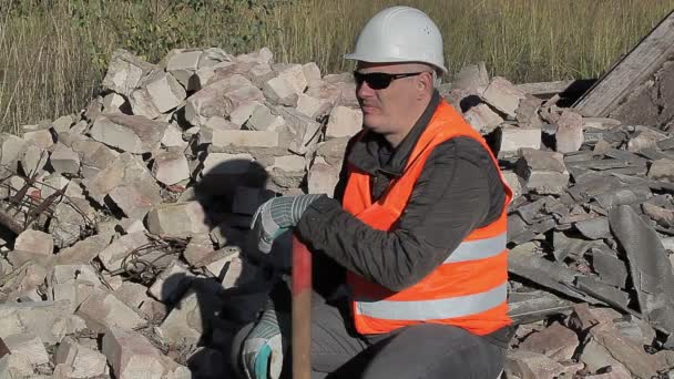 Pracownik budowlany zmęczony w pobliżu stos cegieł — Wideo stockowe