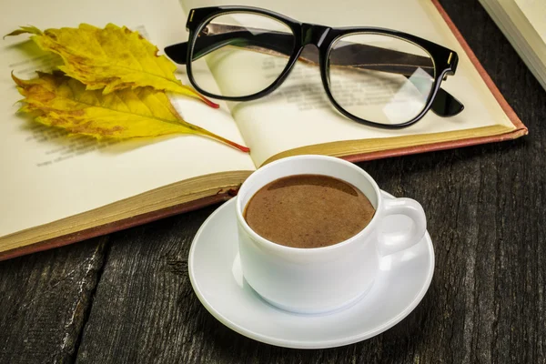 Taza de café con vasos en libro y hojas de otoño — Foto de Stock