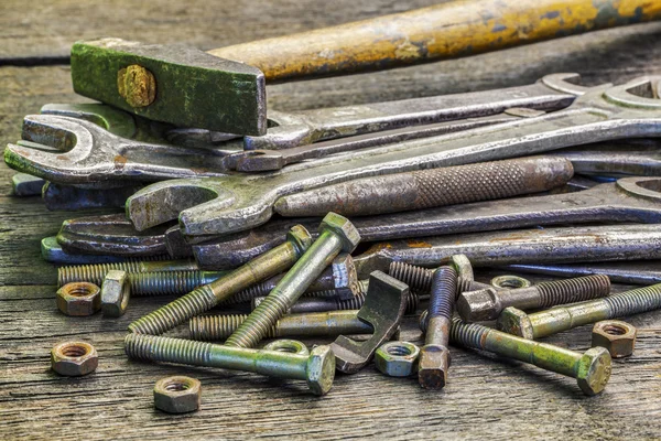 Velho, chaves enferrujadas parafusos, porcas e martelo na mesa — Fotografia de Stock