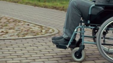 Yolda tekerlekli sandalye kullanan engelli adam