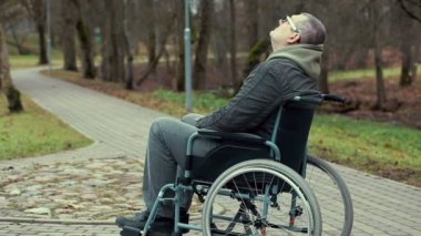 Engelli adam tekerlekli sandalyeye mahkum park yolundaki yardım bekliyor