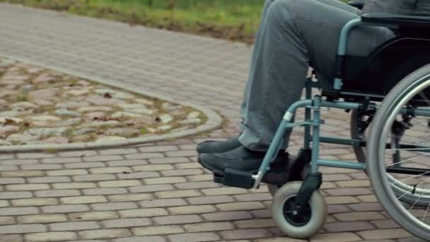 Ανάπηρο άνθρωπο χρησιμοποιώντας τα αναπηρικής πολυθρόνας στην πορεία — Αρχείο Βίντεο