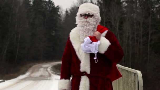 Санта-Клаус с подарочной сумкой на мосту — стоковое видео
