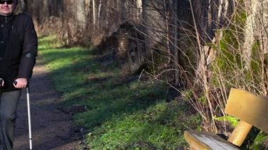 Adam açık, koltuk değneği devre dışı yakınındaki Park banklar