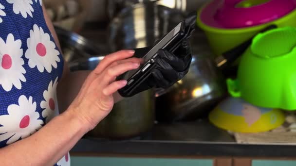 台所でスマート フォンを持つ女性 — ストック動画